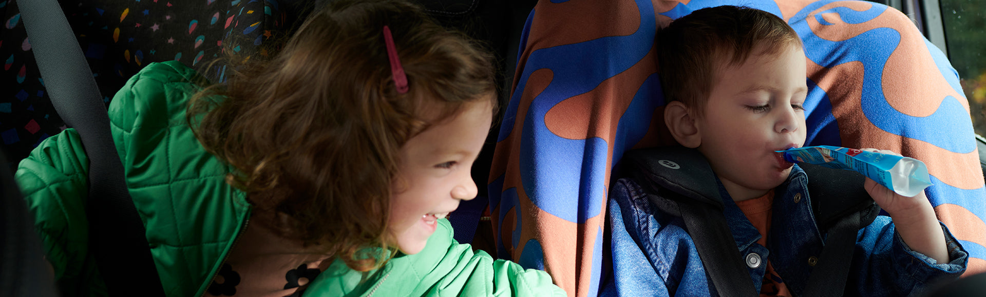 Zwei Kinder im Auto mit Quetschies